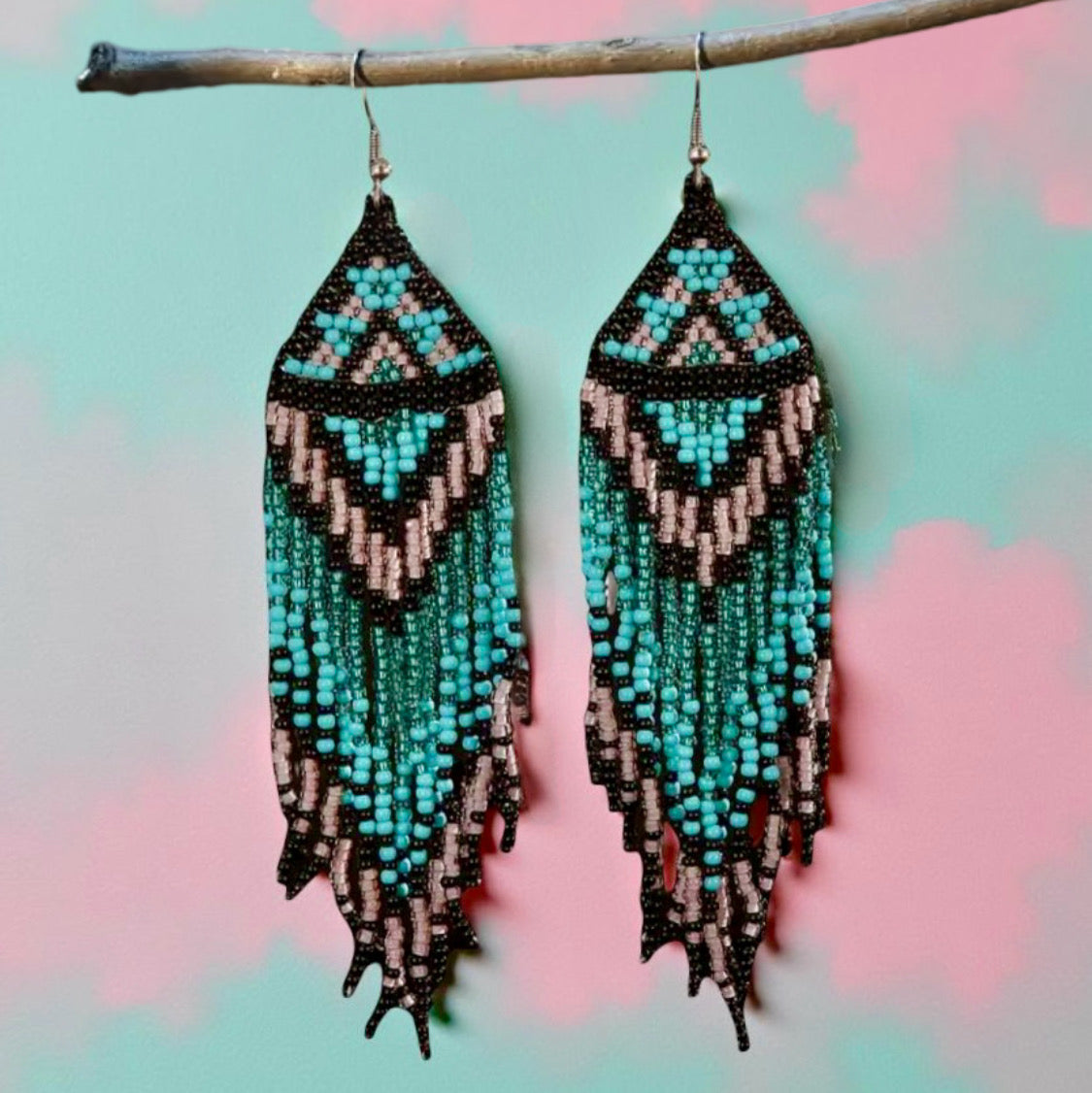 Handmade beaded earrings featuring turquoise and pink long tassel fringe, with hypoallergenic medical-grade 316L surgical steel lever backs, in front of a pastel background