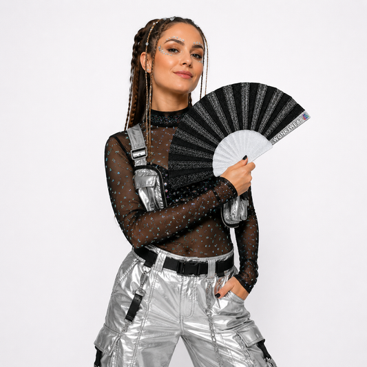 Fully clothed festival model holding a black glitter folding fan during a professional studio photoshoot