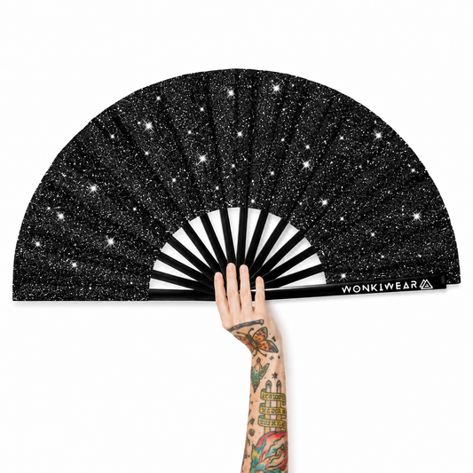 Black glitter folding festival fan with tattooed hand on white background