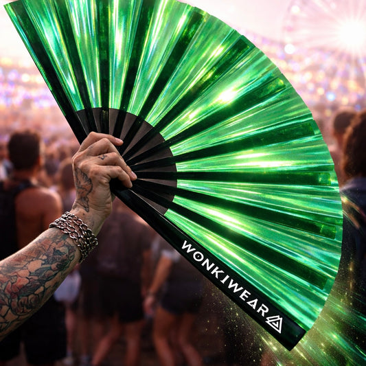 Person holding emerald iridescent festival fan at rave with crowd and lights in background