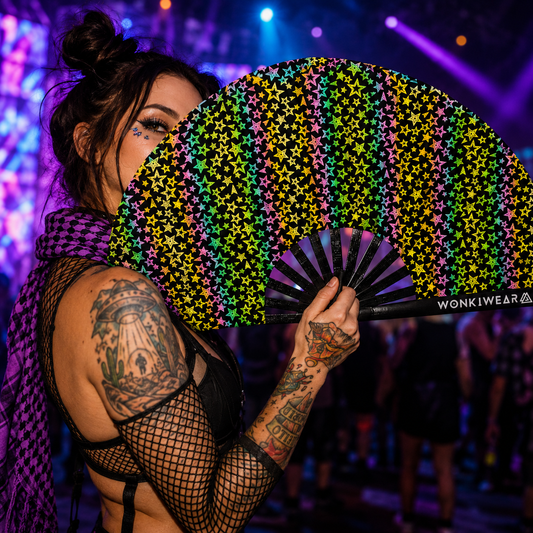 Person holding reflective stars festival fan under colourful rave lighting