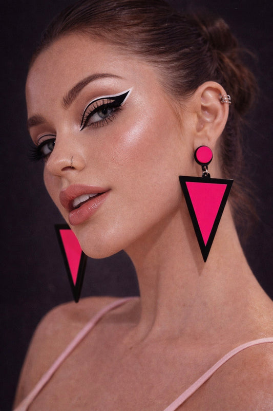 Model wearing pink triangle statement earrings UK