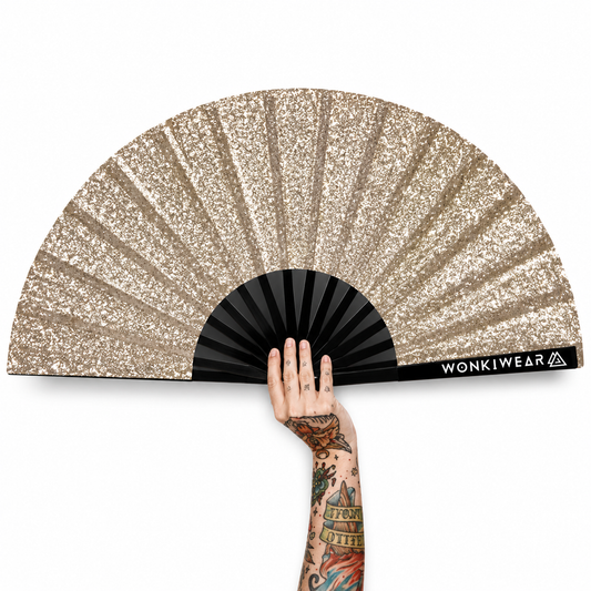 Gold glitter folding festival fan with tattooed hand on white background