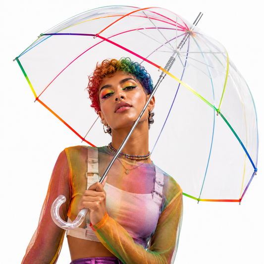 LGBTQ model holding transparent rainbow dome umbrella in studio photoshoot