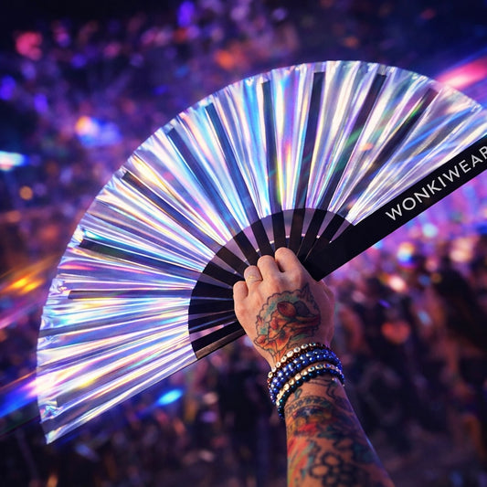 Silver iridescent rave fan reflecting festival lights in crowd at night