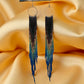 Handmade beaded earrings with extra-long fringe, featuring a black-to-blue gradient design and hypoallergenic 316L surgical steel lever backs.