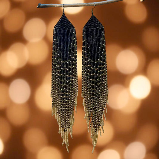 Handmade beaded earrings designed to mimic long feathers, featuring a black and gold cascading bead pattern with hypoallergenic 316L surgical steel lever backs.