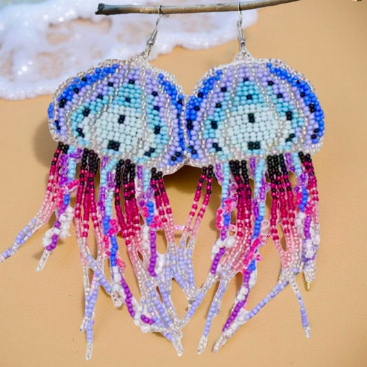 Handmade beaded jellyfish earrings in blue, purple, and pink with delicate flowing tentacles, featuring hypoallergenic surgical steel lever back hooks.
