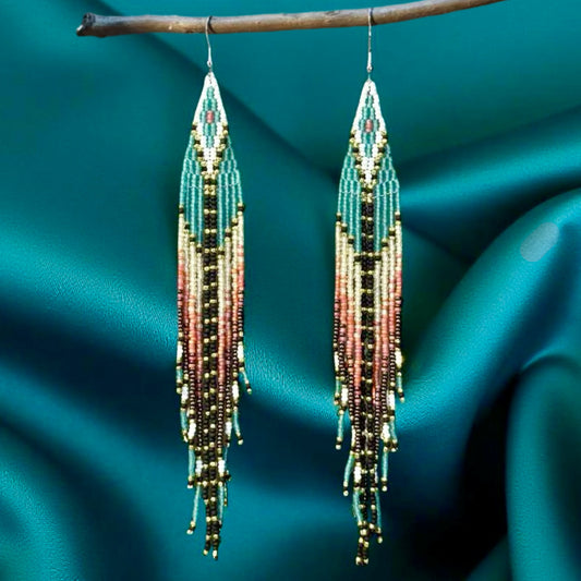 Handmade beaded earrings with long fringe, featuring a mix of teal, gold, black, and soft pink colors, and hypoallergenic 316L surgical steel lever backs.