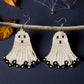 Handmade beaded earrings in the shape of cute white ghosts with black facial details and floral black fringe, perfect for Halloween and spooky season style.