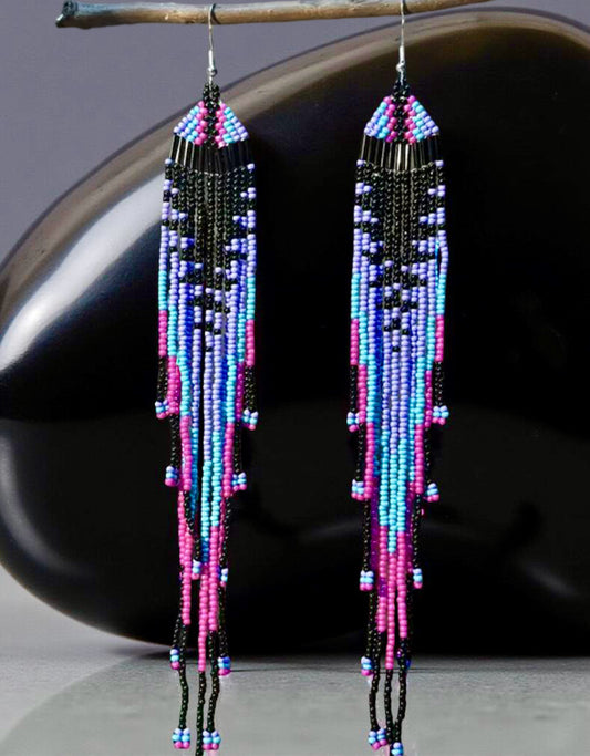 Long beaded earrings with colourful seed beads imitating a jellyfish in front of a shiny black surface