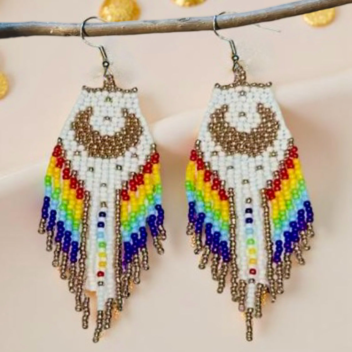 Handmade beaded earrings with a moon design, white and rainbow-colored fringe, and hypoallergenic medical-grade 316L surgical steel lever backs.