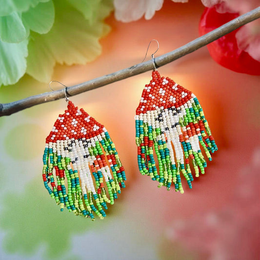 Handmade beaded earrings with a woodland mushroom design, featuring a red mushroom cap. Mounted on surgical steel lever backs.