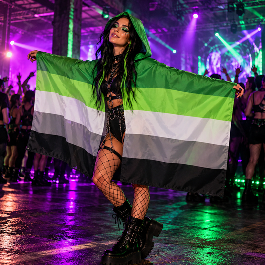 A person wearing a hooded aromantic pride flag at a colourful underground rave.