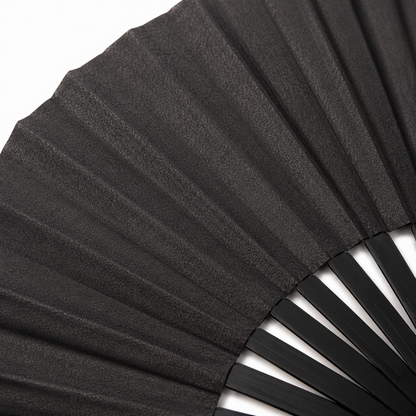 Macro close-up showing the subtle shimmer finish of the black metallic festival fan