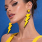 Model wearing yellow lightning bolt earrings UK