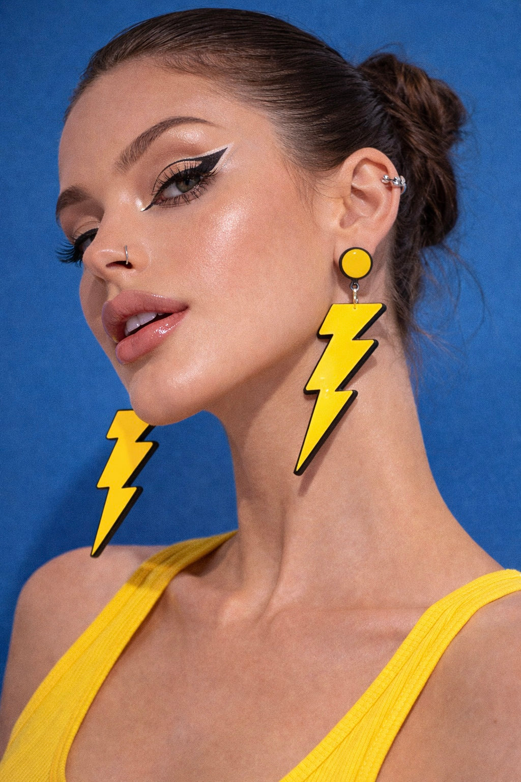 Model wearing yellow lightning bolt earrings UK