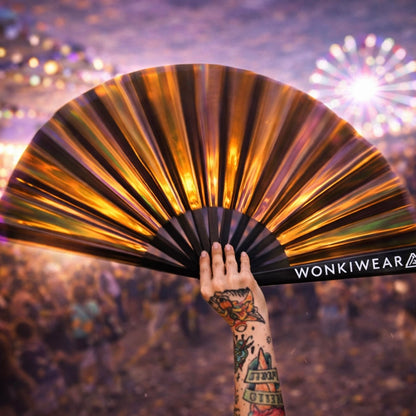 Bronze iridescent rave fan glowing in festival crowd lights at sunset