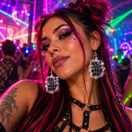Woman wearing clear “IDK, I Just Work Here” statement earrings at a colourful neon rave