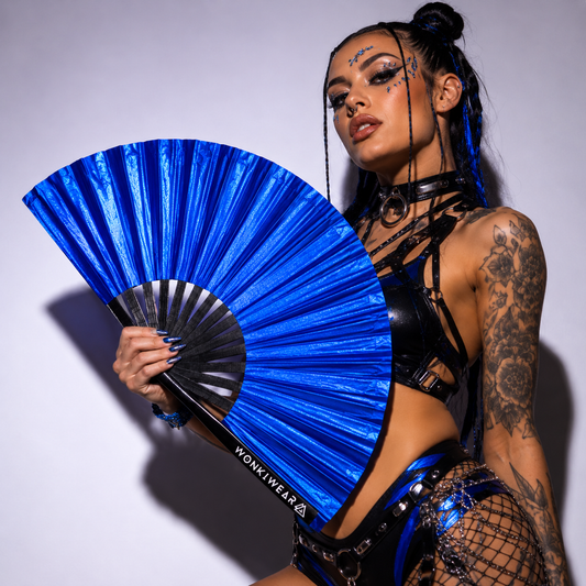 Festival model holding XL cobalt blue shimmer metallic festival fan during studio photoshoot