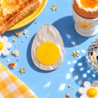 Boiled egg hair clip with pearlescent white finish and bright yellow yolk by Cuteryko
