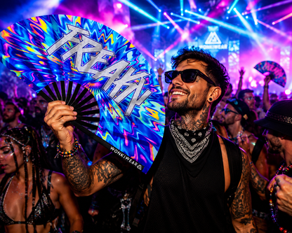 Man holding a psychedelic Freaky XL folding fan at a neon EDM rave festival