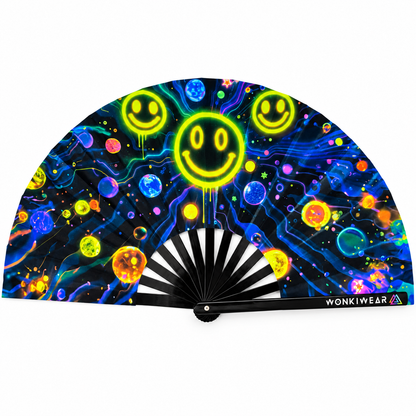 Galactic Grin XL 26-inch UV-reactive folding rave fan by WonkiWear, featuring neon smiley faces, colourful planets and electric blue cosmic artwork on a black background.