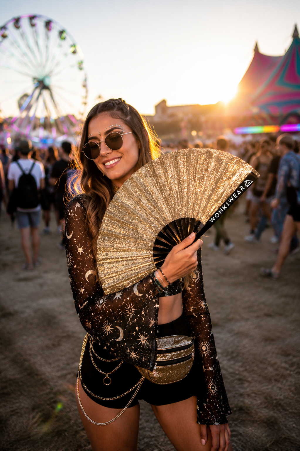 Female festival fashion model holding gold glitter folding rave fan outdoors