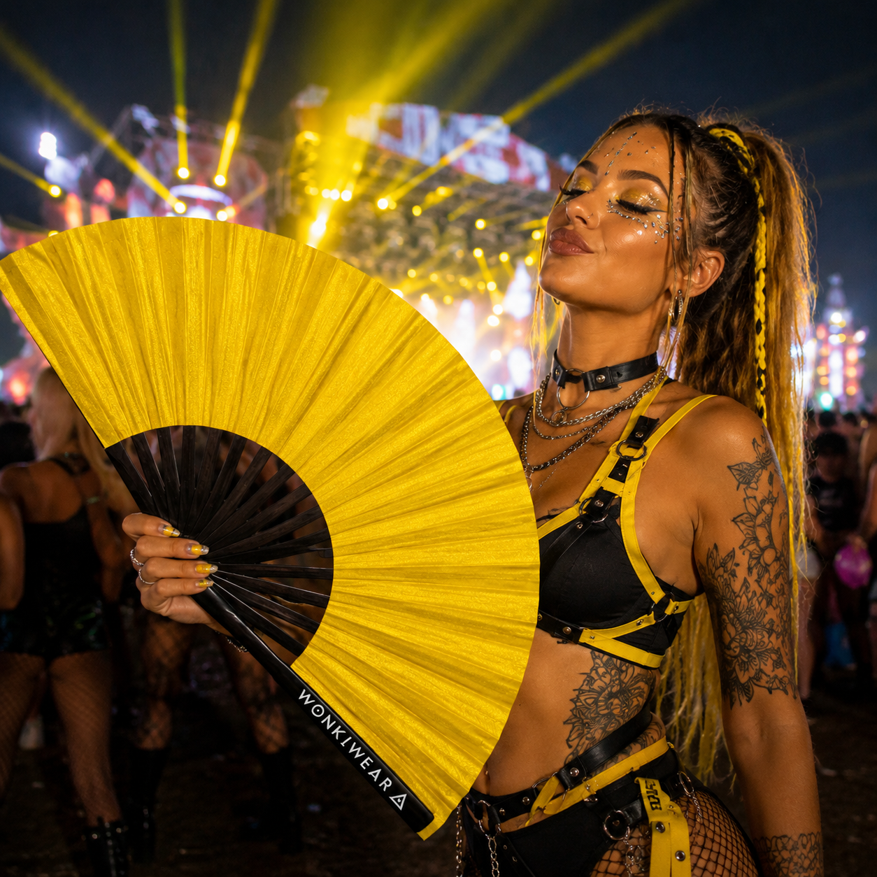 Festival-goer using XL gold shimmer fan at a rave event