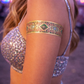Vipassana metallic gold temporary tattoos glowing in natural daylight on arm at festival