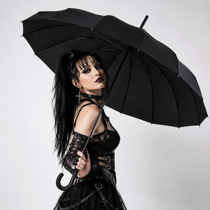 Gothic fashion model posing with black pagoda umbrella in studio setting