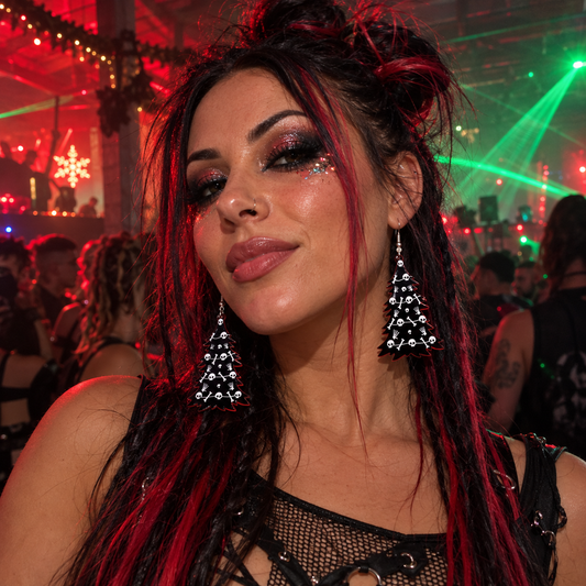 Woman wearing black gothic Christmas tree earrings with skull and bone designs at a festive rave