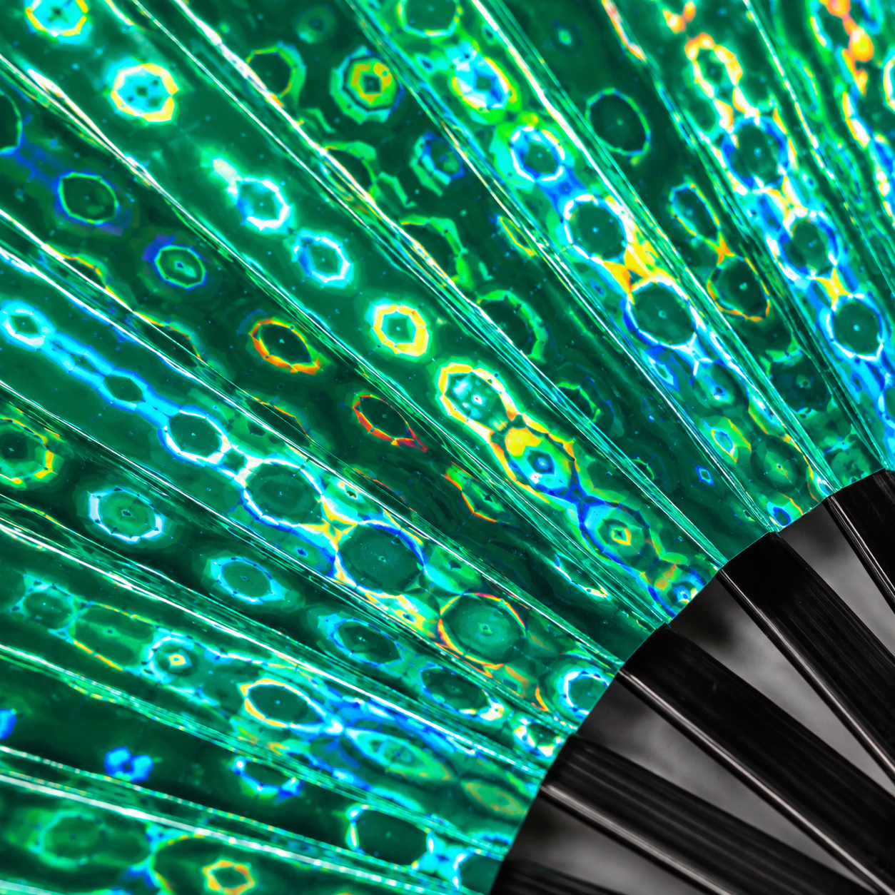 Close-up of green holographic festival fan showing emerald iridescent detail