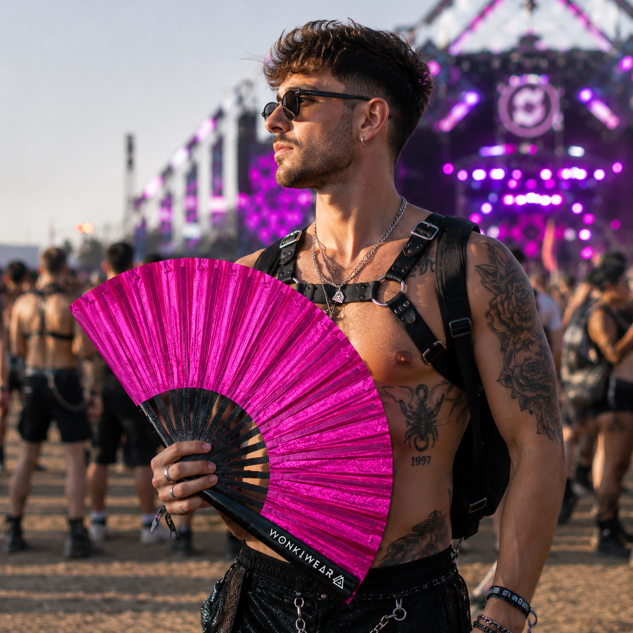 Male festival attendee holding XL hot pink shimmer festival fan at summer event