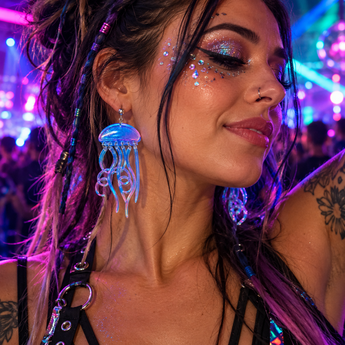 Woman wearing semi-transparent iridescent jellyfish drop earrings at a neon rave festival