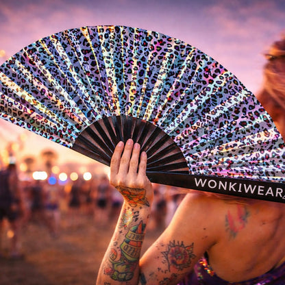 Close up of iridescent leopard fan reflecting festival lights with metallic shine