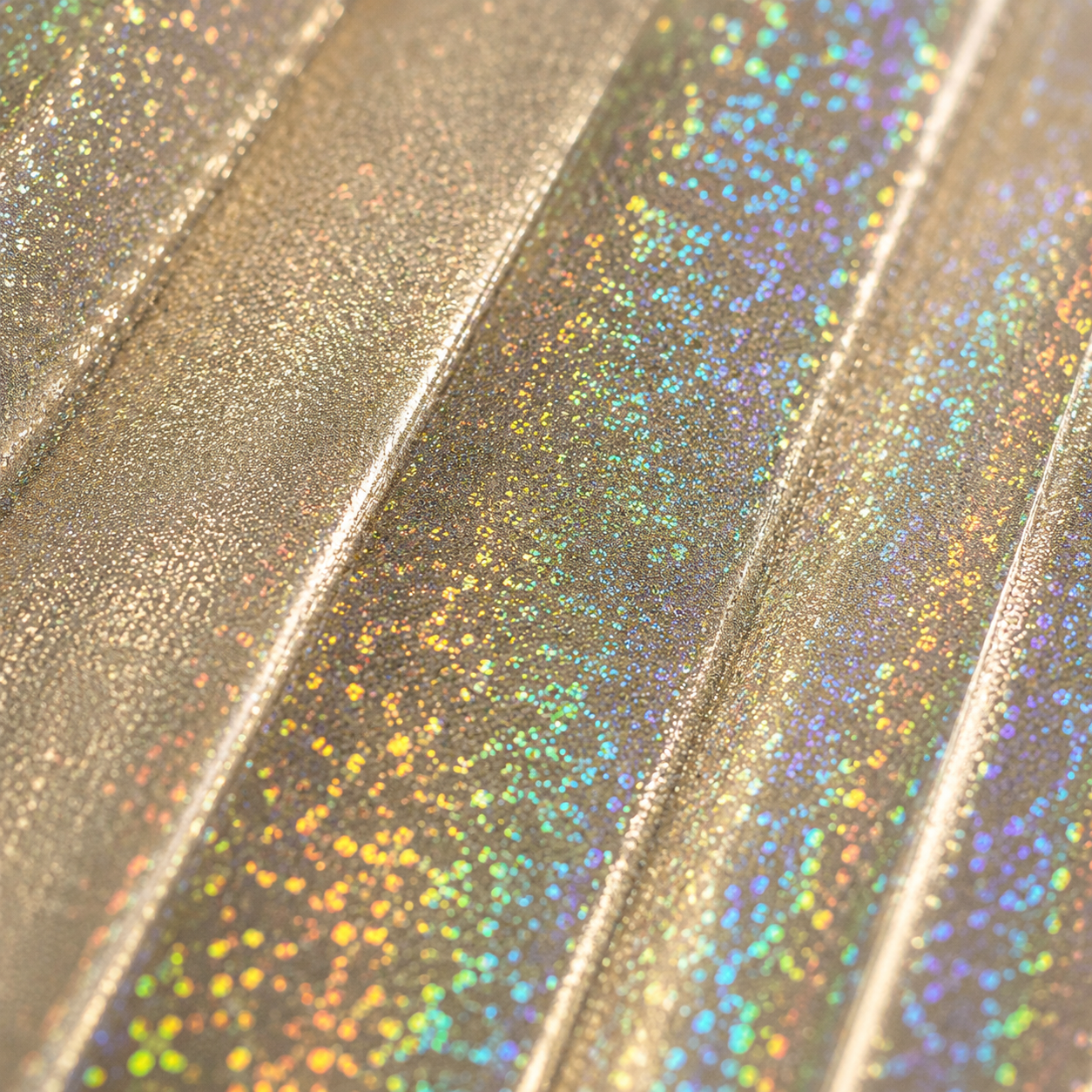 Close up of Jupiter Galaxy holographic champagne gold material showing rainbow reflective detail
