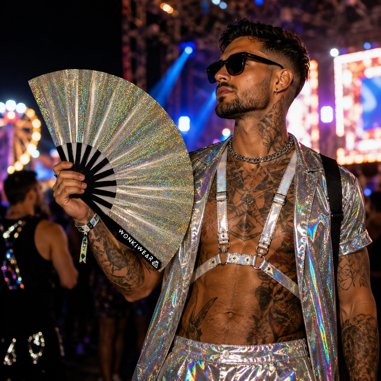 Male festival attendee using Jupiter Galaxy holographic champagne gold fan at a music festival
