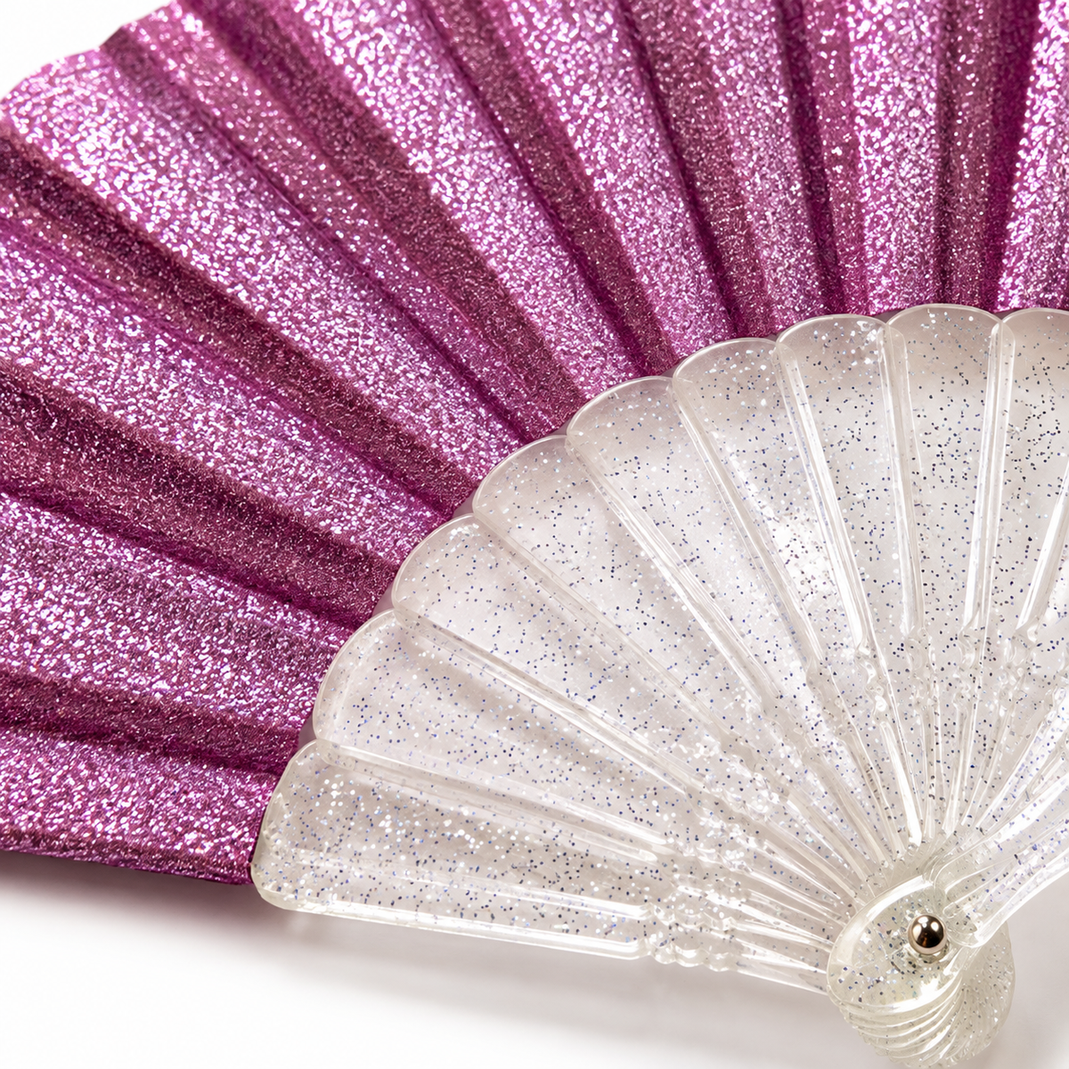 Close-up macro of a lilac glitter mini folding fan highlighting its sparkling pleated fabric and clear transparent ribs flecked with glitter.