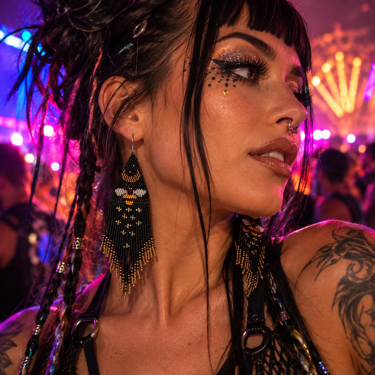 Woman wearing long black and gold beaded bee fringe earrings at a neon rave festival 
