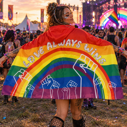 Woman wearing a Love Wins rainbow pride hooded flag at a colourful Pride festival 
