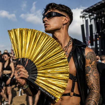 Male festival model holding metallic gold XL rave fan