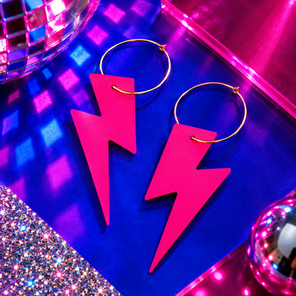 Neon pink cork lightning bolt hoop earrings with gold hoops by Trend Tonic