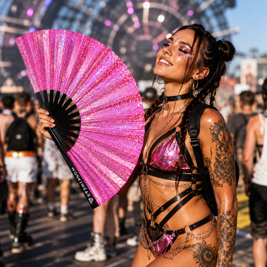 Festival attendee using Orion Galaxy holographic pink festival fan outdoors