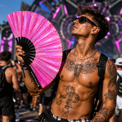 Male festival attendee holding Orion Galaxy holographic metallic pink XL fan