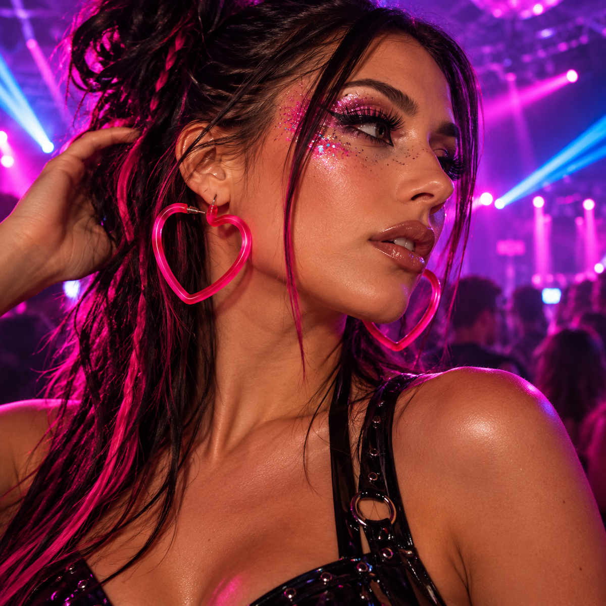 Pink heart-shaped hoop earrings worn by a woman at a neon-lit rave