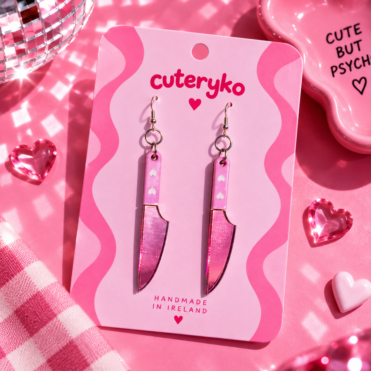 Pink knife earrings with glittery acrylic detail and heart accents by Cuteryko