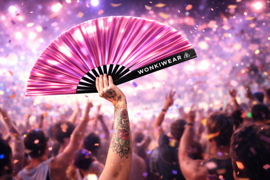 Pink Mirage metallic pink rave fan at festival with crowd and confetti showing reflective iridescent shine