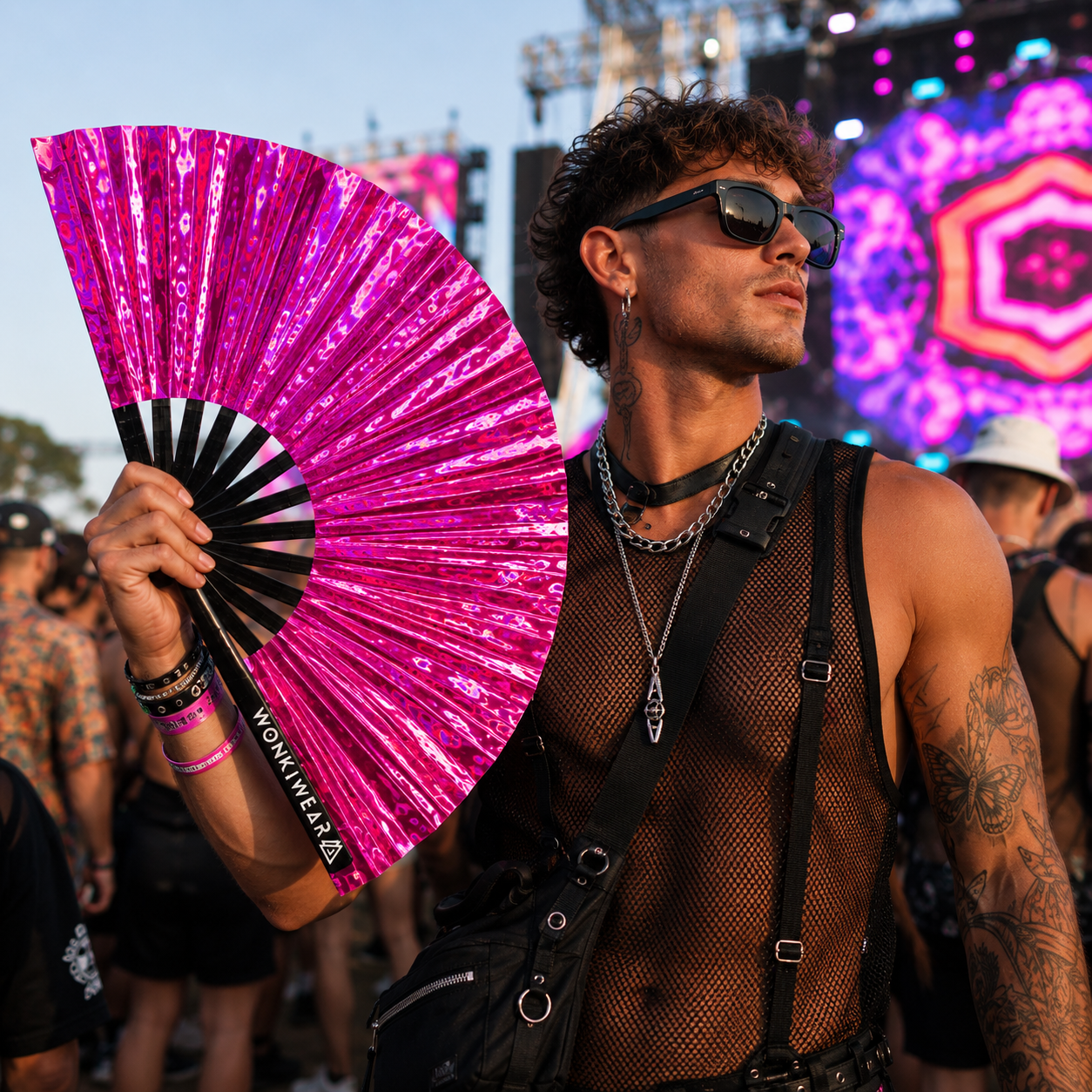 Male festival goer holding Pink Pulse holographic XL festival fan