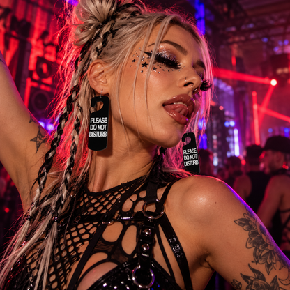Black Please Do Not Disturb door hanger earrings worn by a platinum-haired raver at an underground techno club
